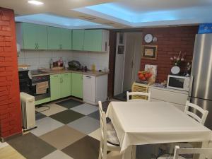 a kitchen with green cabinets and a white table and a table and chairs at Kuća za odmor Pinka House in Sveti Ivan Zelina +8 photos