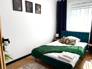 Un dormitorio con una cama con una manta verde. en Ami Luxury Residence XII CENTRUM - możliwość REJSU ŁODZIĄ, en Iława 10 fotos más