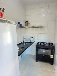 una cucina con lavandino e piano cottura di Samburá Suítes a Japaratinga