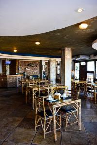 a dining room with wooden tables and chairs at Acuario Pousada in Arraial do Cabo