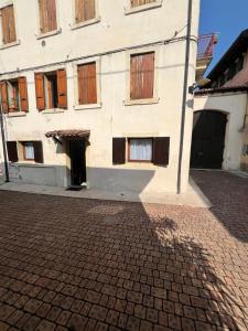 a white building with windows on a brick street at Notti al Castello in Verona