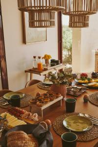 a wooden table with plates of food on it at Casa da Ria in Tavira