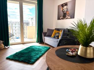 ein Wohnzimmer mit Sofa und Tisch in der Unterkunft Ami Luxury Residence XII CENTRUM - możliwość REJSU ŁODZIĄ in Iława