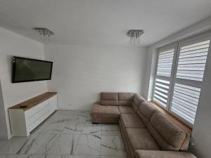 a living room with a couch and a flat screen tv at Apartament Konieczki in Ełk