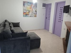 a living room with a couch and a purple door at Nikitas apartment 2 in (( Kermetés )) +6 photos