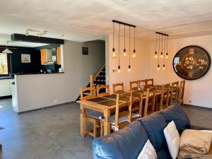 a dining room with a table and a couch at Gîte de la Ferme de Lexhy in Stavelot