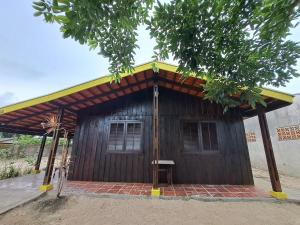 a small wooden building with a yellow roof at Casa com Piscina, Churrasqueira e Quadra de Vôlei! in Pontal do Paraná