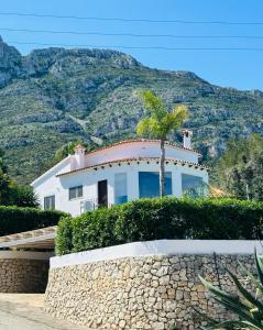ein Haus mit einer Palme auf einer Mauer in der Unterkunft Casa Avellana in Denia