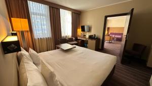 a hotel room with a bed and a living room at Hotel DeSilva Premium Poznań in Poznań