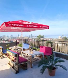 a patio with a table and chairs and an umbrella at Redi house in Batumi