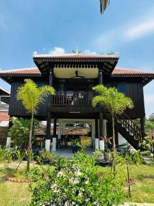 a house with a deck with a table on it at Roya Khmer Homestay in Siem Reap