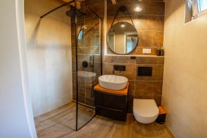 a bathroom with a sink and a toilet and a mirror at Leno Tu - Domki przy jeziorze z sauną i banią in Ciemno