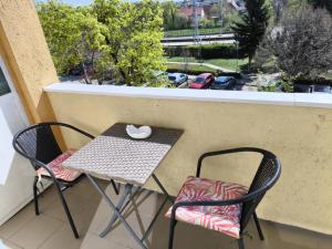 a table and two chairs with a mouse on a balcony at Szeki Apartman in Balatonfüred