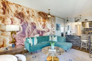 a living room with a couch and a painting on the wall at Luxe Long Beach Condo with Pool 1 Mi to Shoreline! in Long Beach