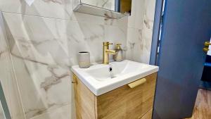 ein weißes Badezimmer mit Waschbecken und Dusche in der Unterkunft L'Ecorce - petit cocon à quelques minutes de Paris in Aubervilliers + 11 Fotos