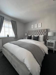 a bedroom with a large white bed and a window at Chadberry House Hotel in Blackpool