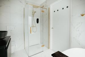 a shower with a glass door in a bathroom at Hotel Janssen in Valkenburg
