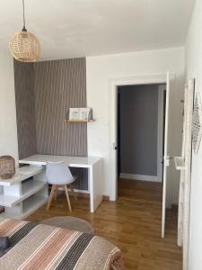 a bedroom with a white desk and a bed at Le petit logelbach in Colmar