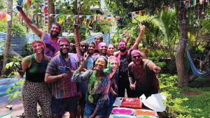 瓦尔卡拉The Hostel Stories, Varkala - Helipad Road的一群人站在蛋糕前,涂上油漆