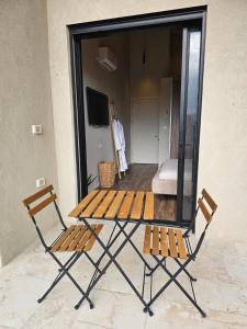 einen Picknicktisch und zwei Stühle vor einem Zimmer in der Unterkunft Villa in the valley in Reẖov
