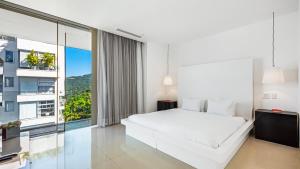 une chambre avec un lit blanc et une grande fenêtre dans l'établissement Avalon - 1004 Stunning Luxury 3 BR Private Pool, à Puerto Vallarta