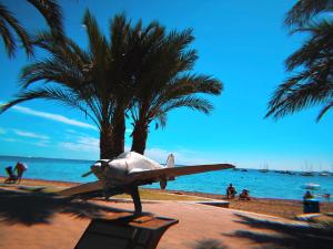 a statue of a plane on a beach with palm trees at Blue Vibes, Relax & Beach in San Javier