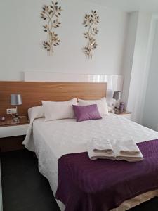 a bedroom with a large bed with two towels on it at Blanco y López in Cee +7 photos