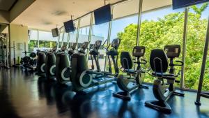 une salle de sport avec des rangées d'appareils cardio devant les fenêtres dans l'établissement Avalon - 1004 Stunning Luxury 3 BR Private Pool, à Puerto Vallarta