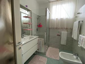 a bathroom with a shower and a sink and a tub at Appartamento Trifoglio in Salò +26 photos