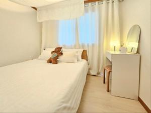 a teddy bear sitting on a bed in a bedroom at Hej Hi Home II in Seoul +36 photos