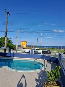 a swimming pool with a view of the ocean at Hotel Vila ÁguaMar in Itapoa