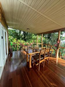 a wooden table and chairs on a porch at Ka Namu in Puerto Viejo +55 photos