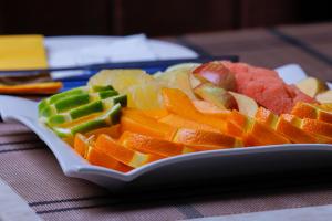 a plate of fruit and vegetables on a table at Rubax motel mbarara in Mbarara