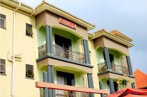 a yellow and green building with a sign on it at Rubax motel mbarara in Mbarara