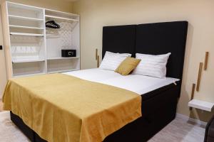 a bedroom with a large bed with a yellow blanket at Tirol Home -Green Apartment in Veliko Tŭrnovo
