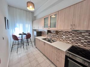 a kitchen with wooden cabinets and a table with chairs at Wake in the Lake III in Agios Nikolaos