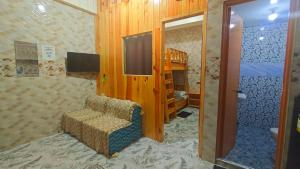 a living room with a chair and a tv in a room at KBC ZAI Baguio Staycation 2 in Baguio