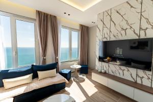 a living room with a blue couch and a television at Maria's Apartment in Durrës