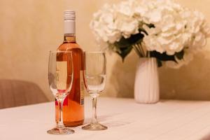 a bottle of wine and two wine glasses on a table at Tirol Home - Apartment in Veliko Tŭrnovo
