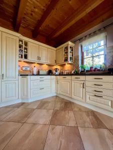 a kitchen with white cabinets and a wooden ceiling at La Dolce Vita im Tiroler-Holzhaus in Bad Elster