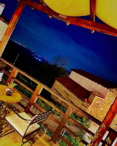 a table and a chair on a porch with a view of the ocean at Varosi Guesthouse in Edessa