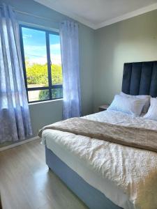 a bedroom with a bed and a large window at Durban North Cozy Haven in Durban