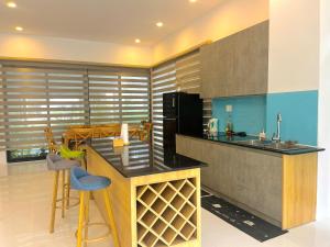 Una cocina con encimera y taburetes en una habitación. en Lucee 4 bedrooms apartment Phu Quoc, en Phu Quoc