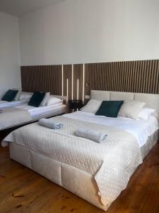 two large beds in a room with wooden floors at Na Deskach Apartments in Żyrardów