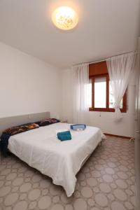 a bedroom with a large white bed in a room at Oasi blu - Charme nel cuore della pineta in Grado-Pineta