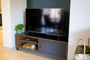 a flat screen tv sitting on a entertainment center at Cosy Connect Guesthouse in Krugersdorp