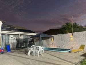 eine Terrasse mit Tisch und Stühlen und ein Swimmingpool in der Unterkunft Casa Kipper in São Gabriel