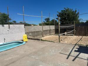 ein Schwimmbad mit einem Zaun und einem Volleyballtor in der Unterkunft Casa Kipper in São Gabriel