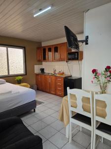 a living room with a bed and a kitchen at Cozy Corner in Paramaribo