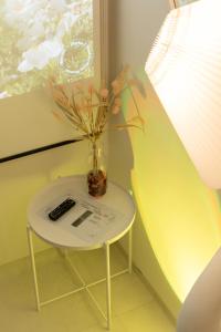 a table with a vase and a remote control on it at Naroo Stay - DDP and Jong-ro in Seoul